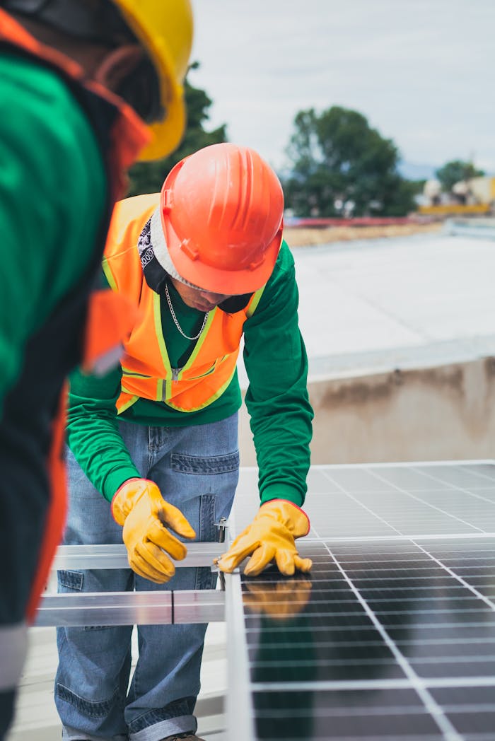 why-choose-us-01 Worker in safety gear installing solar panels on a rooftop.